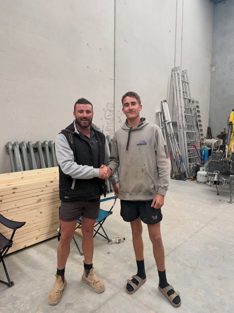 Blake Grant shaking hands in the workshop after finishing his carpentry apprenticeship