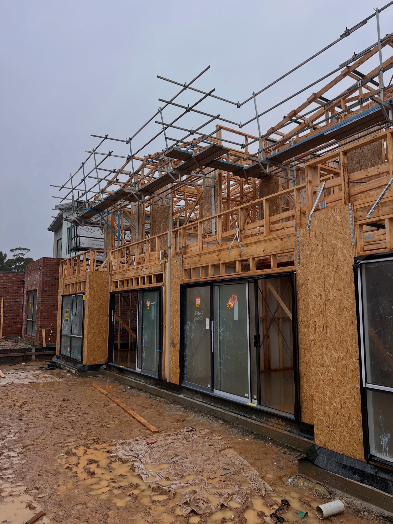 Row of wrapped double-storey townhouse frames in Lilydale