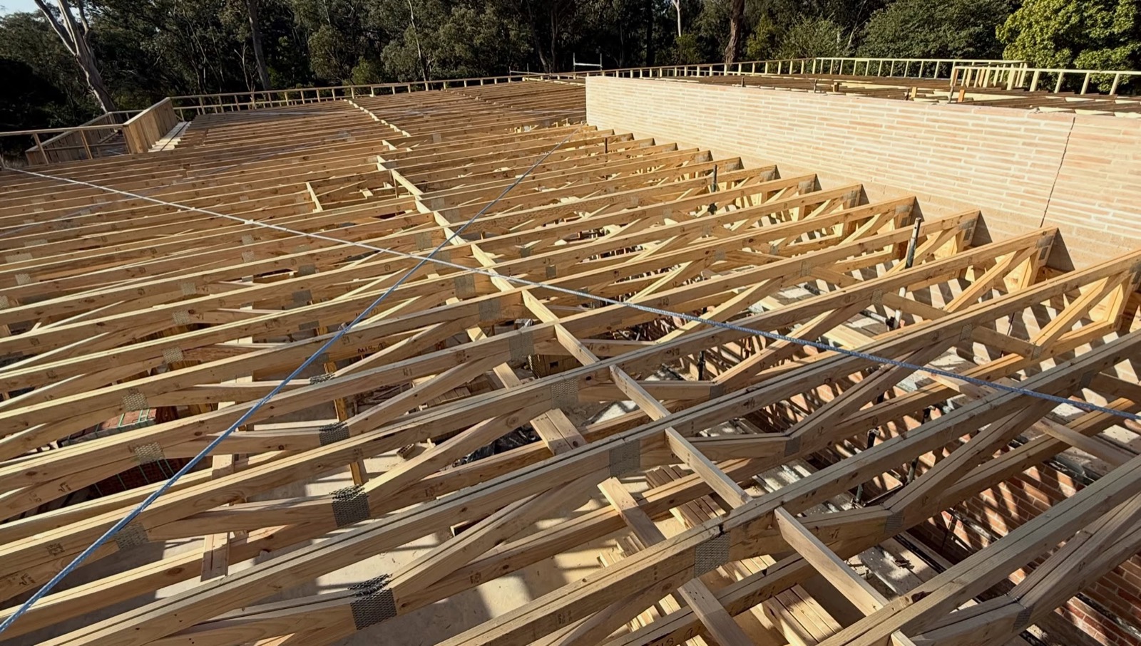Roof framing across a large custom home in Park Orchards, surrounded by gum trees