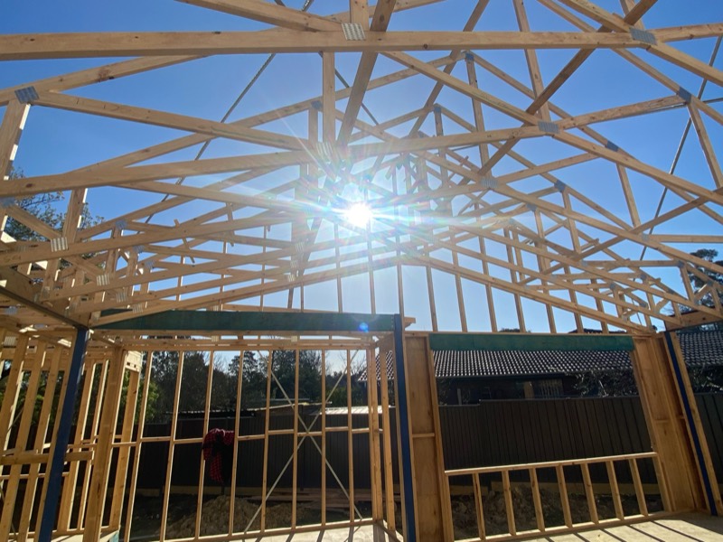 Scissor trusses forming a raked ceiling, with the sun shining through
